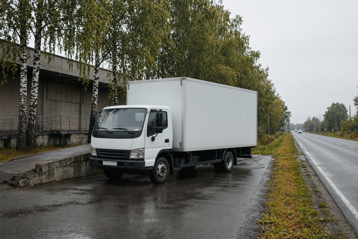 Среднетоннажный фургон у склада на загородной дороге